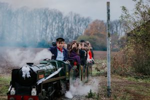 Miniature steam train with wedding guests at Essex wedding