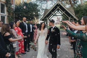 Bride & groom walking through confetti | UK wedding planner 