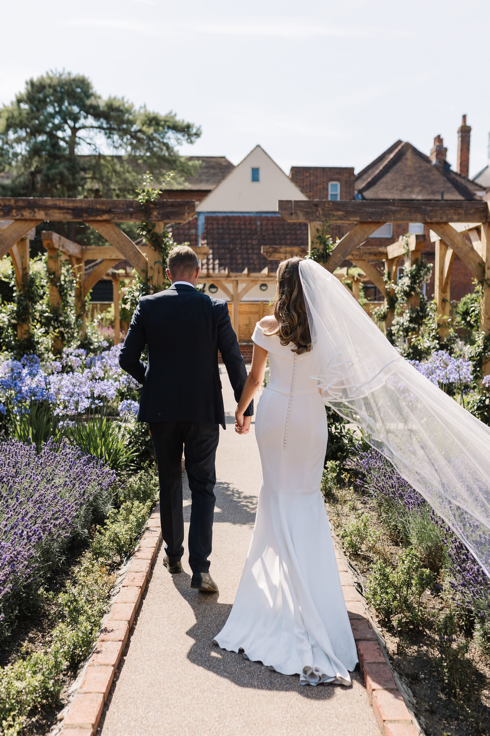 Hayley Jane Wedding & Events Bride & Groom Walking Away from the Camera on Their Wedding Day, Captured in a Relaxed Moment supported by Hayley, Freelance Wedding & Event Coordinator
