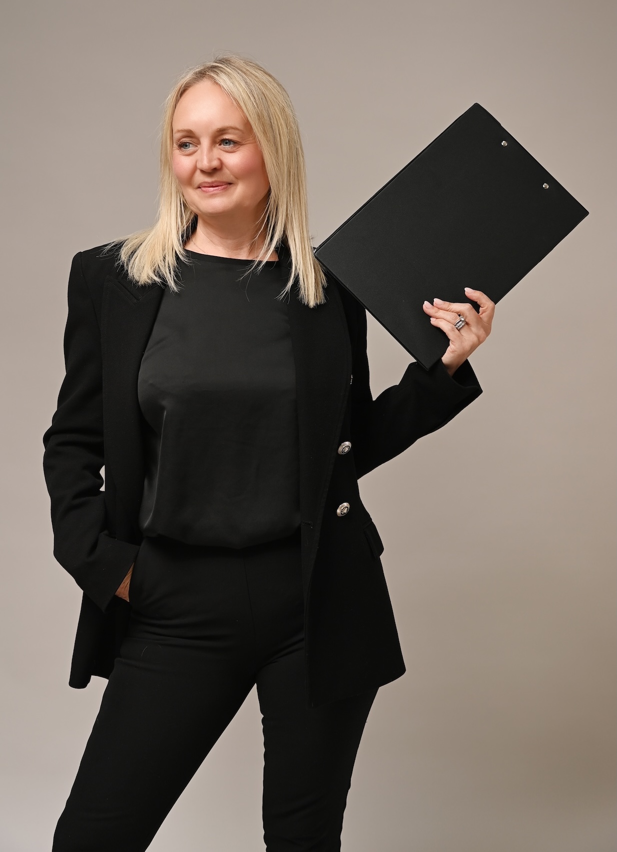 Hayley Wedding & Event Coordinator Hayley Playfully Holding a Clipboard Posing as a Freelance Wedding & Event Coordinator Providing On The Day Support