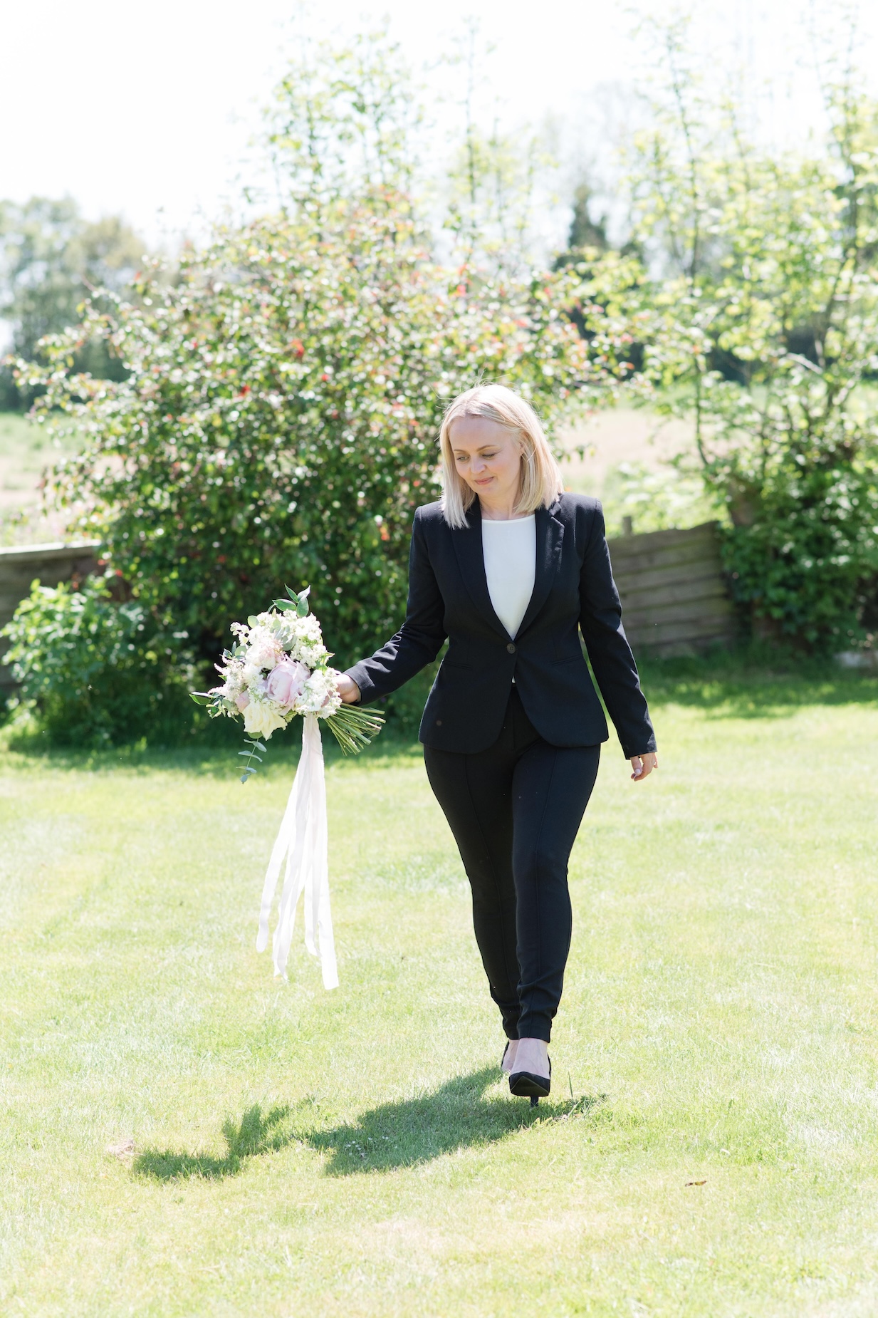 Bride & Groom Walking Away from the Camera Through a Stone Arch on Their Wedding Day, Captured During a Calm Moment Supported by Freelance Wedding & Event Coordinator Hayley